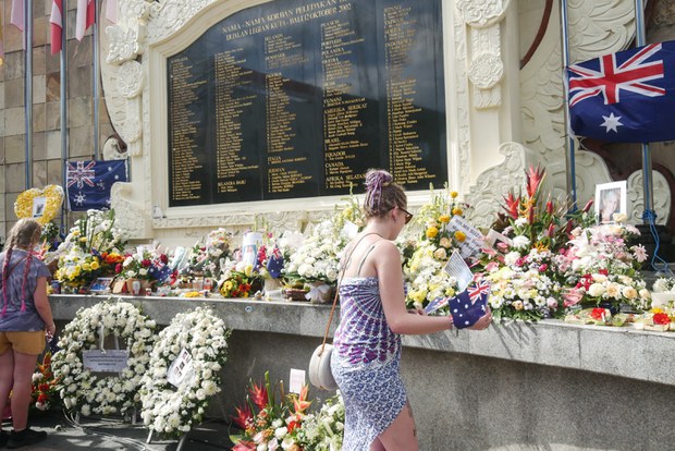 Seorang perempuan meletakkan bunga di Monumen Tragedi Kemanusiaan, di Kuta, Bali, 12 Oktober 2022. [Joan Tanamal/BenarNews]