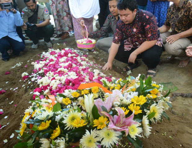 Putra sulung Sutopo, Muhammad Ivanka Rizaldy Nugroho berdoa di pusara ayahnya usai dimakamkan di TPU Sonolayu Boyolali, Jawa Tengah, 8 Juli 2019. (Kusumasari Ayuningtyas/BeritaBenar)