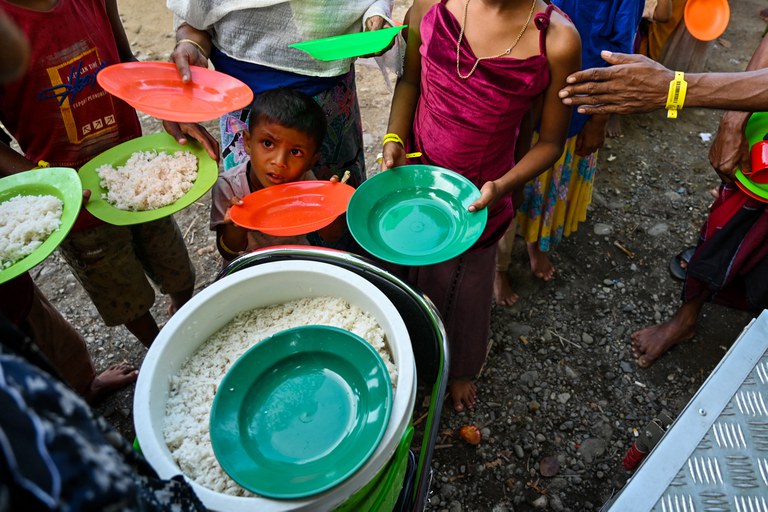 Pengungsi Rohingya antri untuk sarapan di tempat penampungan sementara mereka di Padang Tiji, Kabupaten Pidie, Aceh, pada 16 November 2023. Setidaknya 147 pengungsi mendarat di provinsi paling barat Indonesia itu pada 15 November - kata otoritas seperempat - sehari setelah hampir 200 orang lainnya mendarat di wilayah yang sama. [Chaideer Mahyuddun/AFP]