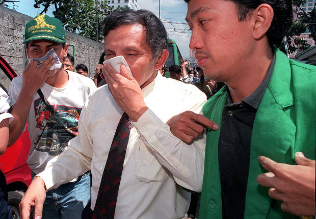 Amien Rais (tengah) menutup mulutnya dari gas airmata yang ditembak polisi di kampus Universitas Trisakti, Jakarta, 13 Mei 1989. (AFP)