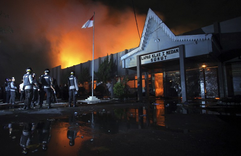 Petugas kepolisian berjaga di luar penjara Tanjung Gusta, yang dibakar oleh narapidana setelah kerusuhan, di Medan, Sumatra Utara, 11 Juli 2013. [Roni Bintang/Reuters]