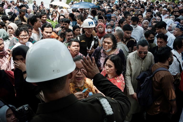 Warga berkumpul untuk menerima bantuan makanan yang didistribusikan oleh Presiden Joko Widodo untuk menyambut Idul Fitri di Istana Kepresidenan di Jakarta pada 10 April 2024. [Yasuyoshi Chiba/AFP]