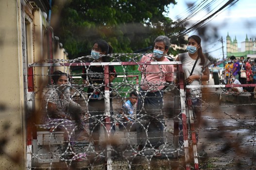 Orang-orang menunggu di luar Penjara Insein di Yangon, Myanmar, ketika otoritas militer mengumumkan bahwa lebih dari 5.000 orang yang dipenjara karena memprotes kudeta Februari yang menggulingkan pemerintah sipil, akan dibebaskan, 18 Oktober 2021. [AFP]