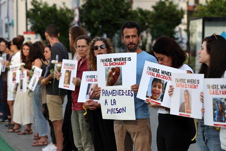 Para pengunjuk rasa Israel membawa foto kerabat mereka yang hilang yang disandera militan Hamas di Jalur Gaza, dan menuntut pembebasan mereka, di luar Kementerian Pertahanan di Tel Aviv pada 19 Oktober 2023 [Ahmad Gharablia/AFP]