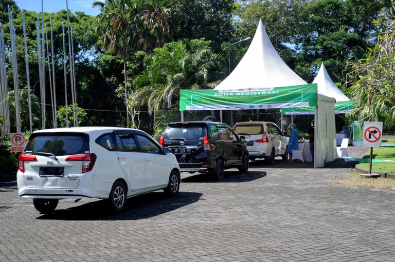 Kendaraan tampak antri di tempat layanan vaksin COVID-19 langsung dari mobil di Nusa Dua, salah satu wilayah dari tiga zona hijau -  zona bebas pandemi virus corona di Bali, 1 Maret 2021. [AFP]
