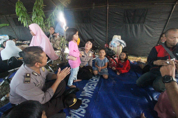 Sejumlah polisi menghibur anak-anak korban gempa dan tsunami Sulawesi Tengah saat tiba di Bandara Sepinggan, Balikpapan, Kalimantan Timur, 4 Oktober 2018. (Gunawan/BeritaBenar)