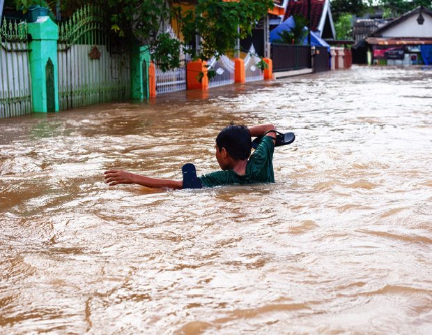 Seorang anak berusaha berenang dalam derasnya banjir di Makassar, Sulawesi Selatan, 23 Januari 2019. (Yusuf Wahil/BeritaBenar) 