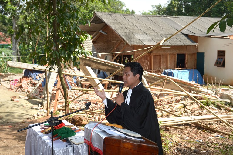 Dalam foto tertanggal 31 Maret 2013 ini, pastor Torang Simanjuntak memberikan misa Minggu Paskah di samping puing-puing Gereja Kristen Protestan Batak Taman Sari di Bekasi, Jawa Barat, yang diruntuhkan pemerintah setempat beberapa hari sebelumnya. [Adek Berry/AFP]