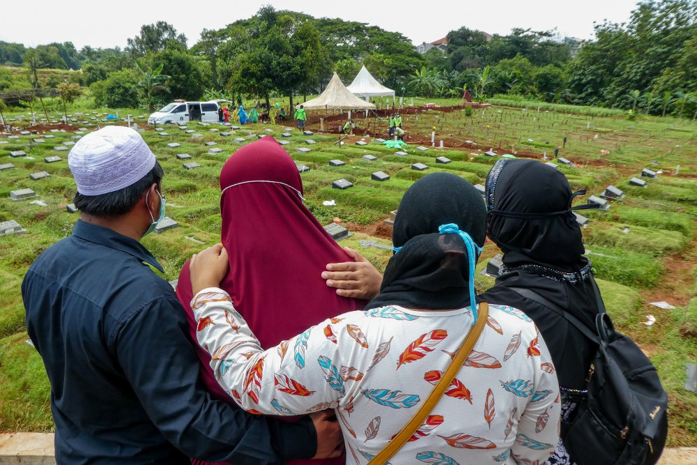 Sanak keluarga meratapi kepergian salah seorang anggota keluarga mereka yang meninggal karena virus corona, di sebuah pemakaman di Jakarta, 31 Maret 2020. [AFP]