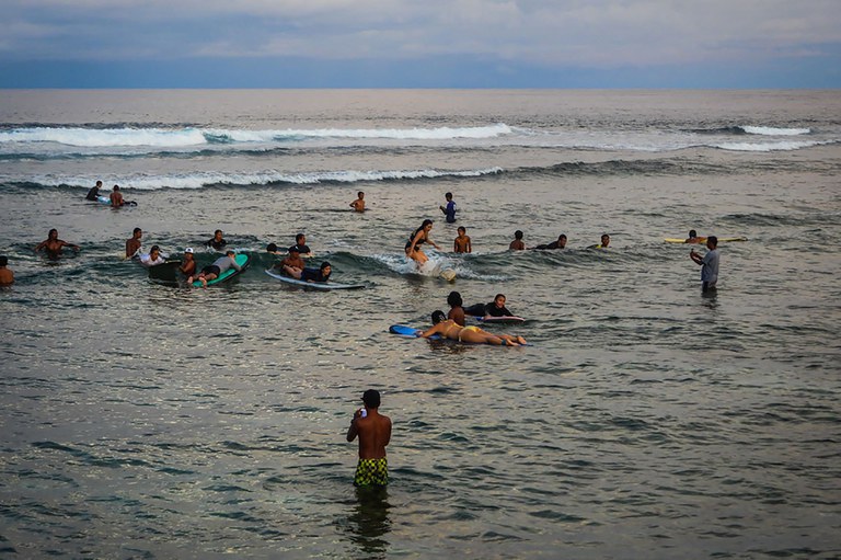 Turis bermain ombak di kota General Luna, di pulau Siargao, Filipina selatan, 7 Oktober 2022. [Ferdinandh Cabrera/AFP]