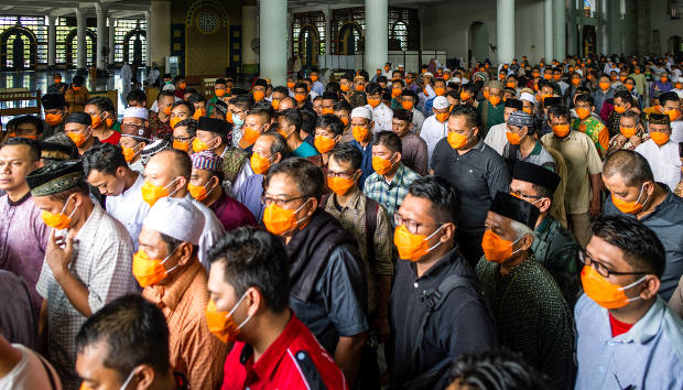 Di tengah wabah COVID-19, jemaah menggunakan masker melakukan salat Jumat di sebuah masjid di Surabaya, 20 Maret 2020. [AFP]