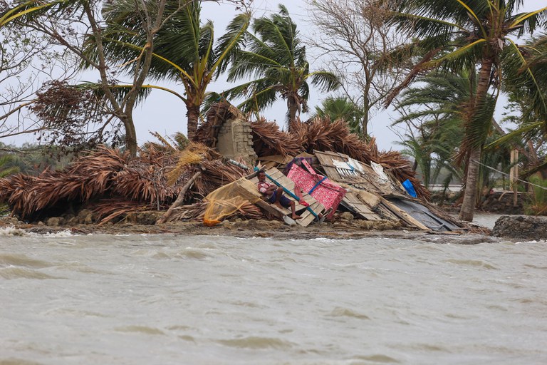Seorang pria beristirahat di puing-puing rumahnya yang dikepung banjir seminggu setelah Topan Amphan melanda daerah di Koyra, Satkhira, di Bangladesh, 27 Mei 2020. [AFP]
