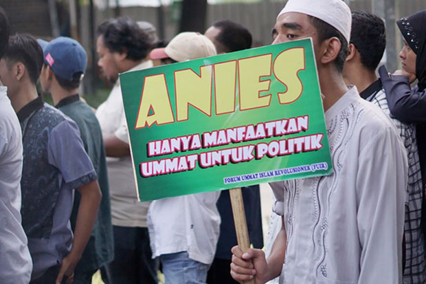 Seorang demonstran memegang poster saat ikut aksi unjuk rasa di depan Gedung DPRD DKI Jakarta, 19 Maret 2018. (Arie Firdaus/BeritaBenar)