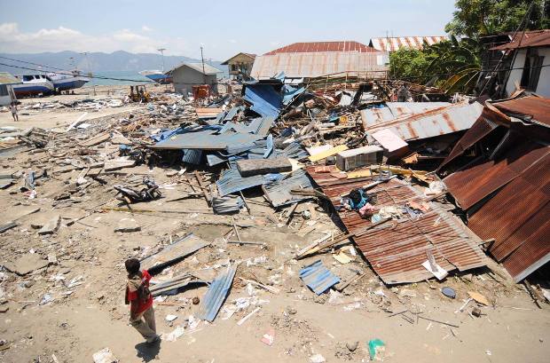 Warga mencari barang yang bisa diselamatkan di tengah puing-puing bangunan yang hancur akibat gempa dan terjangan tsunami empat hari sebelumnya di Desa Wani II, Kecamatan Tanantovea, Kabupaten Donggala, Sulawesi Tengah, 2 Oktober 2018. (Keisyah Aprilia/BeritaBenar)