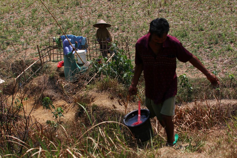 Warga mengambil air dan mencuci pakaian di lubang persawahan yang masih menyimpan air di kawasan desa Weninggalih, Jonggol, Kabupaten Bogor, Jawa Barat, 11 September 2023. Mengambil air di persawahan ini terpaksa dilakukan para warga untuk mencuci dan memenuhi kebutuhan sehari hari, meskipun airnya terasa asin. [Eko Siswono Toyudho/BenarNews]