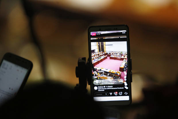 Seorang wartawan merekam suasana Rapat Dengar Pendapat Umum Komisi I DPR RI dan Perwakilan Facebook di Jakarta, 17 April 2018. (Rina Chadijah/BeritaBenar)