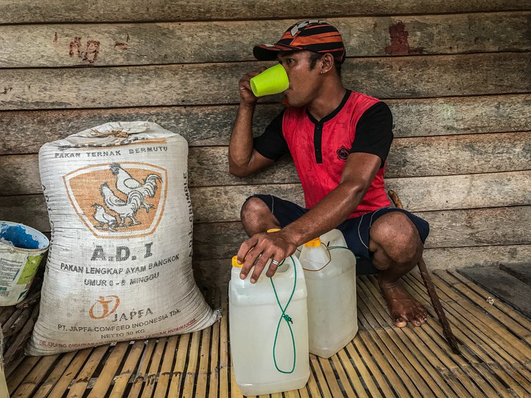 Syahrul Calu (37) meminum air yang baru diambilnya di mata air sungai Desa Renggeang, Kecamatan Limboro, Kabupaten Polewali Mandar, Provinsi Sulawesi Barat, 11 Mei 2022. Air bersih ini bisa langsung diminum tanpa harus dimasak. Rasanya pun menurut warga tak ubahnya rasa air mineral kemasan yang banyak dijual di pasaran. Meski belum ada penilitian khusus dari pemerintah tentang air ini, namun warga di Desa Renggeang mengaku air ini tidak membuat perut mereka sakit ketika dikonsumsi. “Air ini suci dan sudah turun temurun diminum oleh warga,” demikian kata Syahrul. Warga pun menyebutnya sebagai “air kehidupan”. [Keisyah Aprilia/BenarNews]