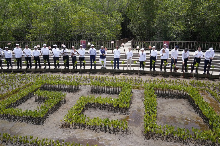 Para pemimpin mengangkat cangkul untuk foto bersama saat acara penanaman pohon mangrove di Taman Hutan Raya Ngurah Rai, di sela-sela pertemuan KTT G20, dekat Denpasar, Indonesia, 16 November 2022 [Alex Brandon, Pool/AP]