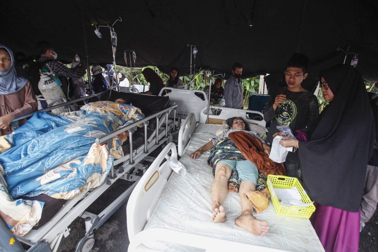Para korban luka-luka mendapatkan perawatan di bawah tenda darurat di halaman sebuah rumah sakit setelah gempa bumi di Cianjur, Jawa Barat, pada 21 November 2022. [STR/AFP]