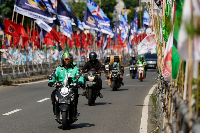 Pengendara di sebuah jalan yang penuh dengan bendera partai politik di Jakarta, 12 Januari 2024. [Willy Kurniawan/Reuters]