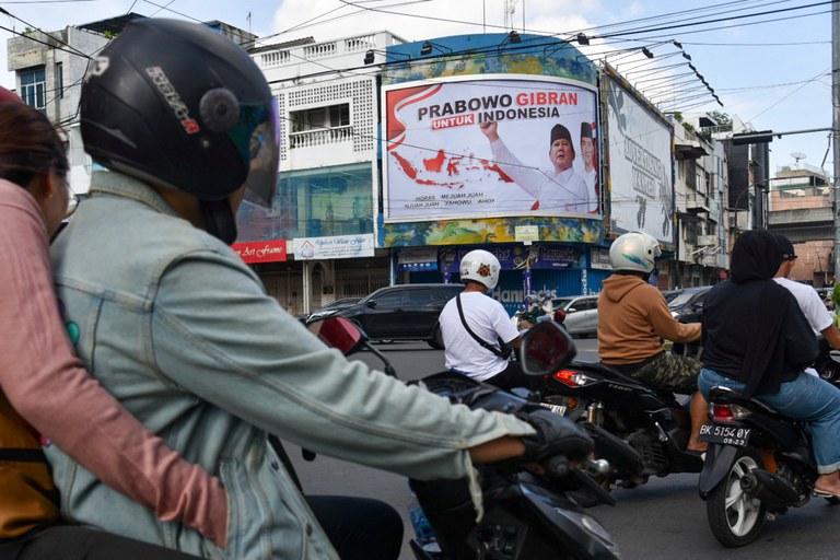 Pengendara melewati baliho bergambar Prabowo Subianto, Ketua Umum Partai Gerindra, salah satu bakal calon presiden dalam pemilu tahun depan, didampingi foto Gibran Rakabuming Raka, putra sulung Presiden Joko "Jokowi" Widodo yang juga Wali Kota Surakarta dengan teks bertuliskan "Prabowo Gibran untuk Indonesia", di Medan, Sumatra Utara,  15 Oktober 2023. [Antara Foto/Fransisco Carolio/via Reuters]