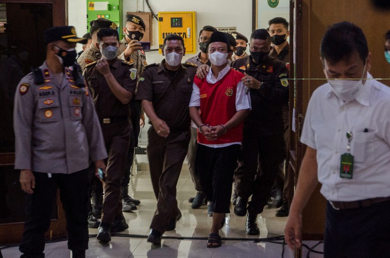 Polisi mengawal Herry Wirawan ke ruang sidang sebelum diputuskannya vonis dalam persidangannya di pengadilan negeri di Bandung, 15 Februari 2022 [Foto Antara via REUTERS]