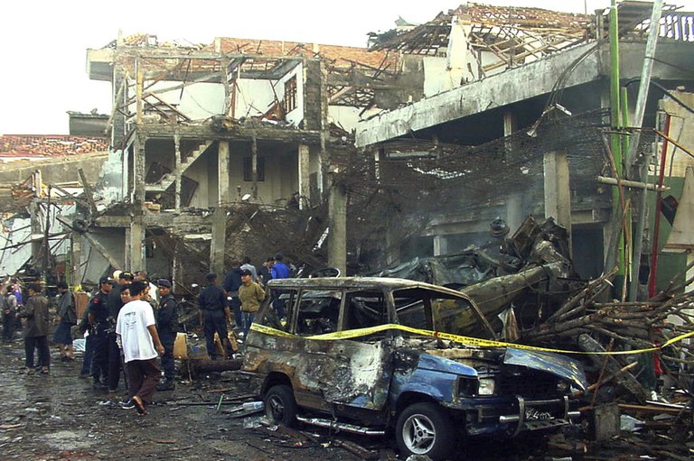 Polisi memeriksa reruntuhan bangunan yang hancur sehari setelah ledakan bom di Kuta, Bali, pada 13 Oktober 2002. Umar Patek, pembuat bom dalam aksi terorisme di Bali tahun 2002 yang menewaskan 202 orang itu, dibebaskan secara bersyarat pada Rabu, 7 Desember 2022, setelah menjalani setengah dari masa hukuman 20 tahunnya, meskipun ditentang oleh Pemerintah Australia yang warganya merupakan korban tewas terbanyak dalam serangan itu. [Foto AP, File]