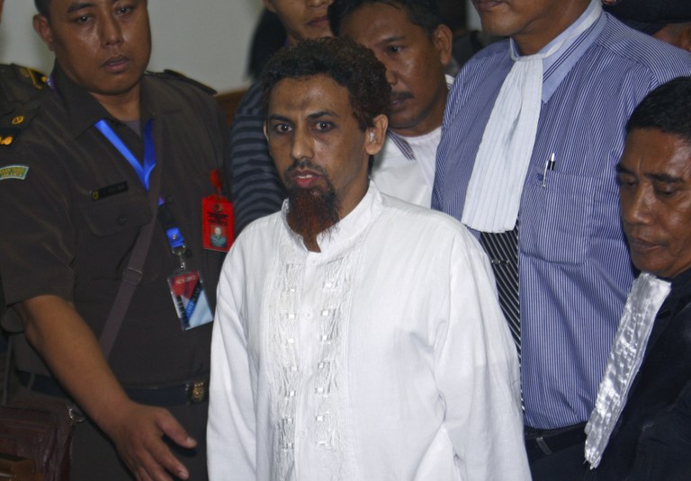 Umar Patek, yang didakwa membantu membuat bom dalam serangan teror bom Bali, meninggalkan sidang pengadilannya di Jakarta pada 21 Mei 2012. [Tatan Syuflana, AP Photo]