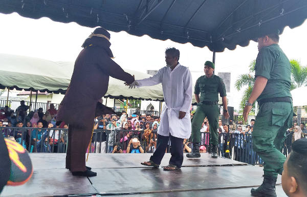 Ridwan MR bersalaman dengan algojo usai dicambuk 19 kali di Banda Aceh, 27 Februari 2018. (Nurdin Hasan/BeritaBenar)