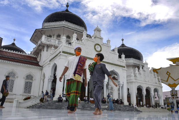 Warga meninggalkan Masjid Baiturrahman setelah melaksanakan Salat Jumat pada bulan Ramadan di tengah situasi wabah COVID-19, di Banda Aceh, 1 Mei 2020. [AFP]