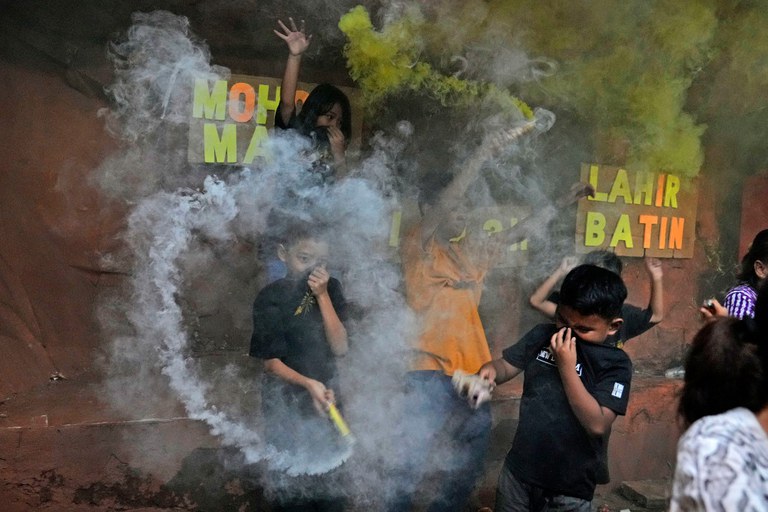 Anak-anak bermain petasan menandai berakhirnya Ramadan dan datangnya Idul Fitri di Jakarta, 1 Mei 2022. [AP]