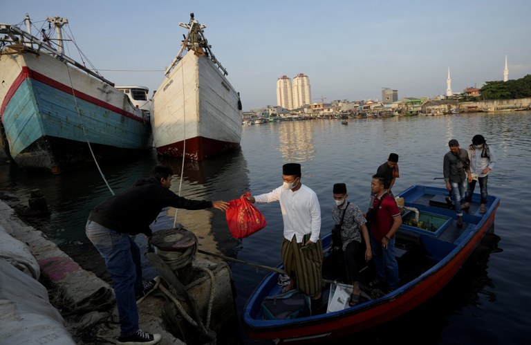Warga tiba dengan perahu untuk mengikuti salat Idul Fitri di pelabuhan Sunda Kelapa di Jakarta, 2 Mei 2022. [AP]