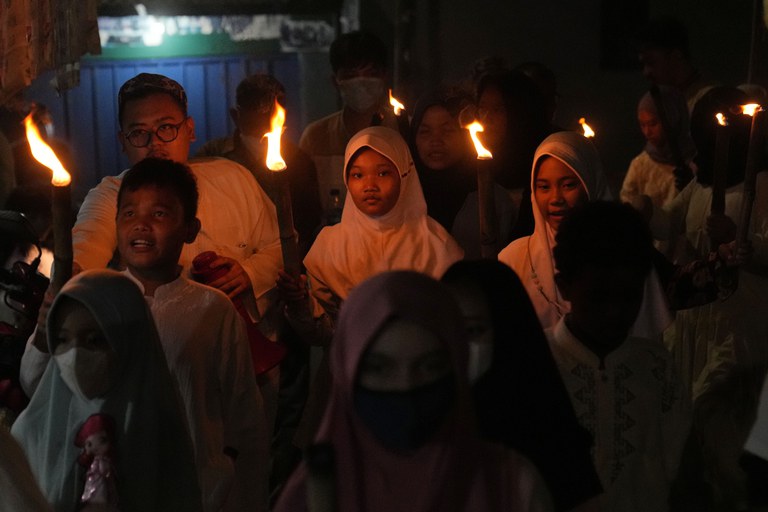 Anak-anak gembira ikut memeriahkan pawai obor pada malam hari menyambut datangnya Idulfitri di Jakarta, 1 Mei 2022. [AP]