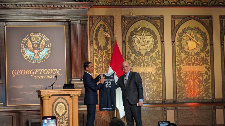 Presiden Indonesia Joko “Jokowi” Widodo (kiri) menerima hadiah jersey universitas dari Joel Hellman, dekan School of Foreign Service, di Georgetown University di Washington, 13 November 2023. [Nazmul Ahasan/BenarNews]