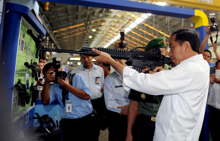 Dalam foto selebaran dari Istana Kepresidenan yang diambil pada 12 Januari 2015 dan dirilis pada 3 Juli 2015 ini, Presiden Indonesia Joko Widodo memeriksa senjata api buatan lokal saat berkunjung ke industri pertahanan BUMN, PT Pindad di Bandung, Jawa Barat. [Rusman/Istana Kepresidenan/AFP]