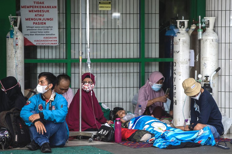 Warga menunggu perawatan di luar ruang gawat darurat sebuah rumah sakit yang merawat pasien Covid-19 di Surabaya pada 11 Juli 2021, di tengah melonjaknya kasus virus corona yang dipicu oleh varian Delta yang sangat menular. [ AFP]