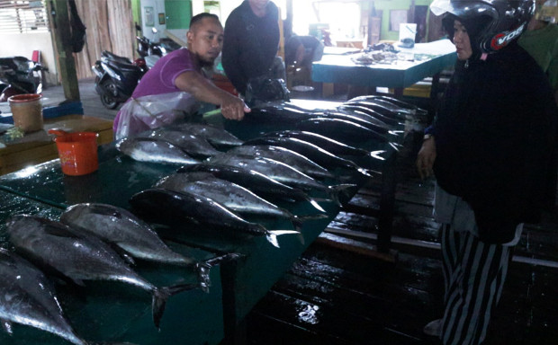 Seorang penjual ikan (kiri) menjual ikan kepada seorang pelanggan di sebuah pasar di Ranai, di Kabupaten Natuna, 6 Desember 2019. [Nosa Normanda/BeritaBenar]