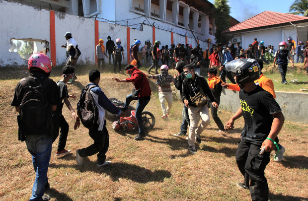Para mahasiswa merusak sebuah sepeda motor di lokasi gedung DPRD Sulawesi Tenggara di  tengah-tengah protes menolak UU KPK, RUU KUHP, dan peraturan lainnya yang dianggap tidak pro rakyat, di Kendari, Sulawesi Tenggara, 26 September 2019. (Reuters)
