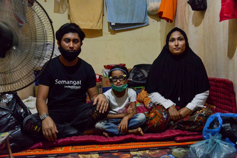 Dalam foto tertanggal 22 Oktober 2020 ini seorang Rohingya, Nemah Shah (kiri), bersama putrinya yang berusia enam tahun Nosmin Fatimah dan istrinya Majuma (kanan) di sebuah penampungan pengungsi di Lhokseumawe di provinsi Aceh. [AFP]