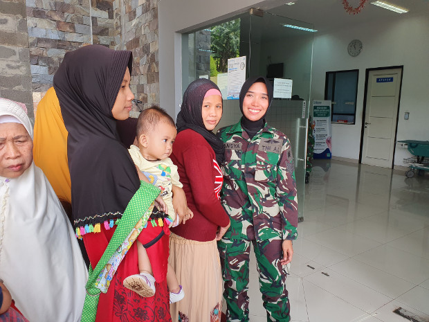 Tansya Susan, anggota pasukan perdamaian Indonesia, berpose bersama warga yang turut serta mendapatkan pelayanan kesehatan gratis di klinik Pusat Misi Pemeliharaan Perdamaian (PMPP) TNI di Sentul, Jawa Barat, 6 Agustus 2019. (Ahmad Syamsudin/BeritaBenar)
