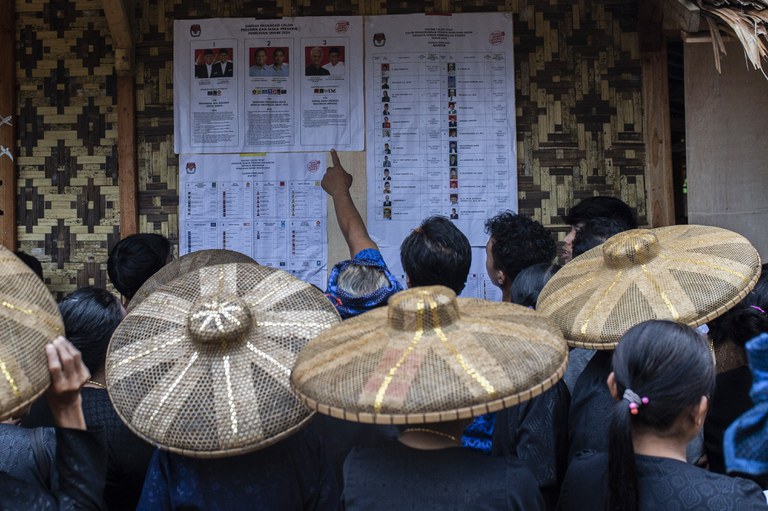 Anggota suku asli Baduy memeriksa daftar para kandidat yang bertarung dalam Pemilu 2024 di sebuat TPS di Desa Kanekes, Lebak, provinsi Banten pada 14 Februari 2024. [Aditya Aji/AFP]