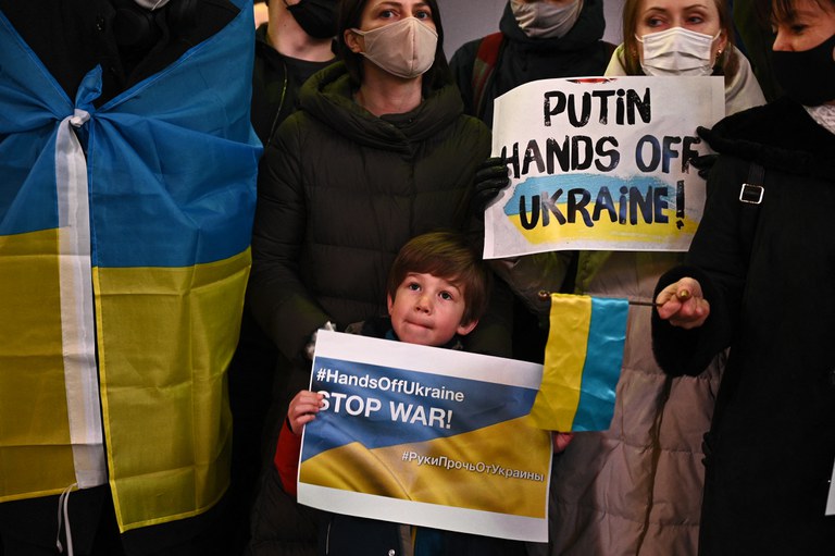 Seorang anak membawa poster berbunyi “Hentikan Perang” sementara yang lainnya membawa poster bertuliskan “Putin Lepaskan Cengkeramanmu atas Ukraina” dalam demonstrasi mengecam serangan Rusia atas Ukraina di Shibuya, Tokyo, 24 Februari 2022. [AFP]