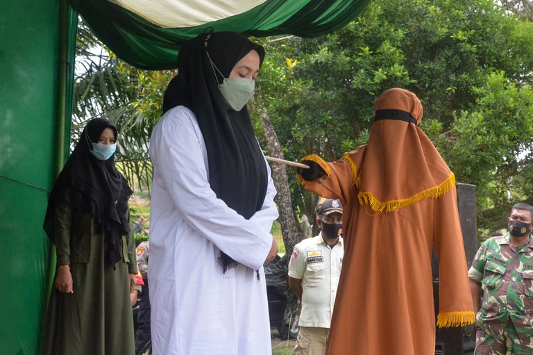 Dalam foto tertanggal 13 Januari 2022 ini, seorang perempuan dicambuk 100 kali karena berzina di Aceh Timur, sementara pasangan prianya, yang membantah tuduhan itu, menerima 15 cambukan. [AFP]
