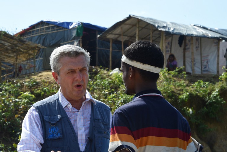 Komisaris Tinggi PBB untuk Pengungsi Filippo Grandi berbicara dengan seorang pengungsi dalam kunjungannya ke kamp pengungsi Kutupalong di Bangladesh yang menampung para pengungsi Rohingya yang melarikan diri dari persekusi di Myanmar, negara asal mereka, pada 23 September 2017. [Dominique Faget/AFP]