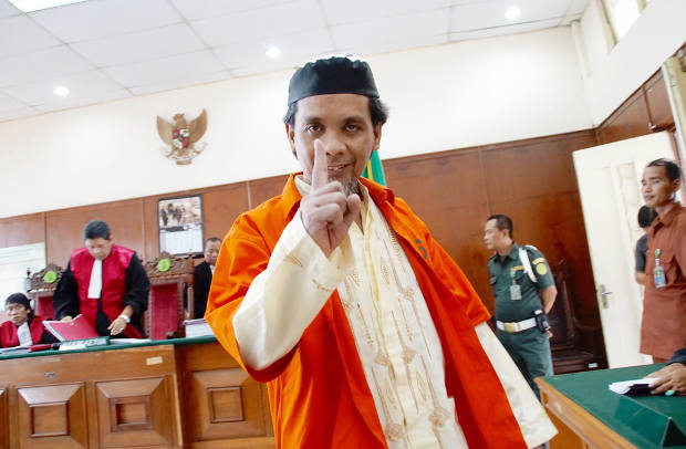 Terdakwa kasus terorisme, Syawaludin Pakpahan, mengangkat jarinya saat persidangan di Pengadilan Negeri Jakarta Utara, 23 April 2018. (Arie Firdaus/BeritaBenar)