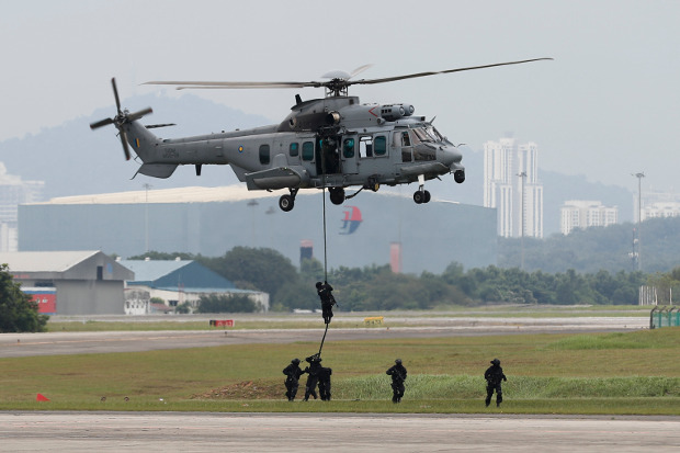 Pasukan khusus mendemonstrasikan keahlian mereka dalam latihan penanganan terorisme dari helikopter sesudah peluncuran patroli gabungan antara Malaysia, Indonesia dan Filipina di pangkalan militer Subang, di Petaling Jaya, Malaysia, 12 Oktober 2017. [AP]
