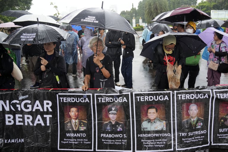 Para keluarga korban penculikan dan penghilangan aktivis prodemokrasi oleh aparat keamanan pada tahun 1998 melakukan “Aksi Kamisan” - protes yang dilakukan setiap hari Kamis selama lebih dari dua dekade, berdiri di dekat spanduk bergambar para jenderal TNI yang dituduh melakukan pelanggaran hak asasi manusia di masa lalu, termasuk di antaranya adalah Prabowo Subianto, kandidat yang terpilih sebagai pemenang presiden Pemilu 2024, di Jakarta, 15 Februari 2024. (Dita Alangkara/AP)