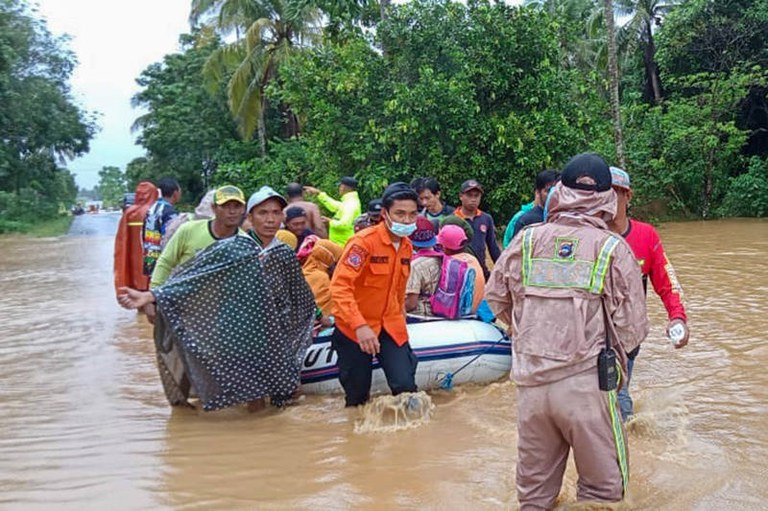 Foto yang diambil dan dirilis pada 15 Januari 2021 oleh Badan Nasional Penanggulangan Bencana Indonesia (BNPB) ini menunjukkan para penyelamat mengevakuasi penduduk desa dengan perahu karet di daerah banjir di kabupaten Tanah Laut, Kalimantan Selatan.[AFP]