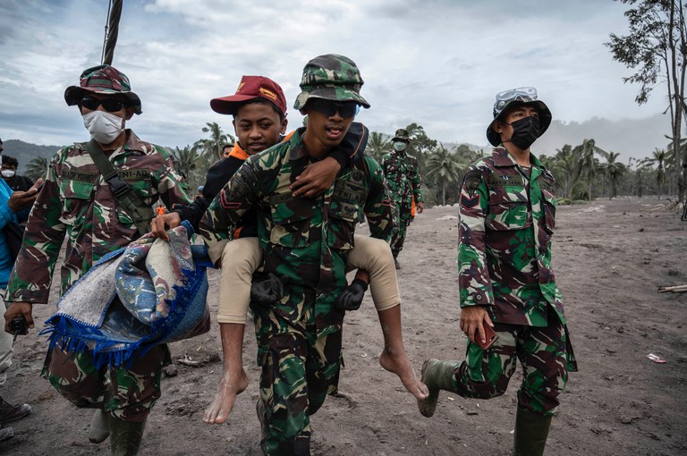 Tim penyelamat membantu evakuasi warga di desa Sumberwuluh, Lumajang, Jawa Timur pada 6 Desember 2021. [AFP]