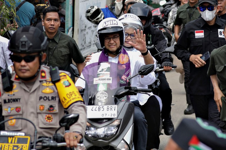 Calon presiden Anies Baswedan mengendarai sepeda motor bersama istrinya Fery Farhati saat memulai kampanyenya di Jakarta, 28 November 2023. [Ajeng Dinar Ulfiana/Reuters]